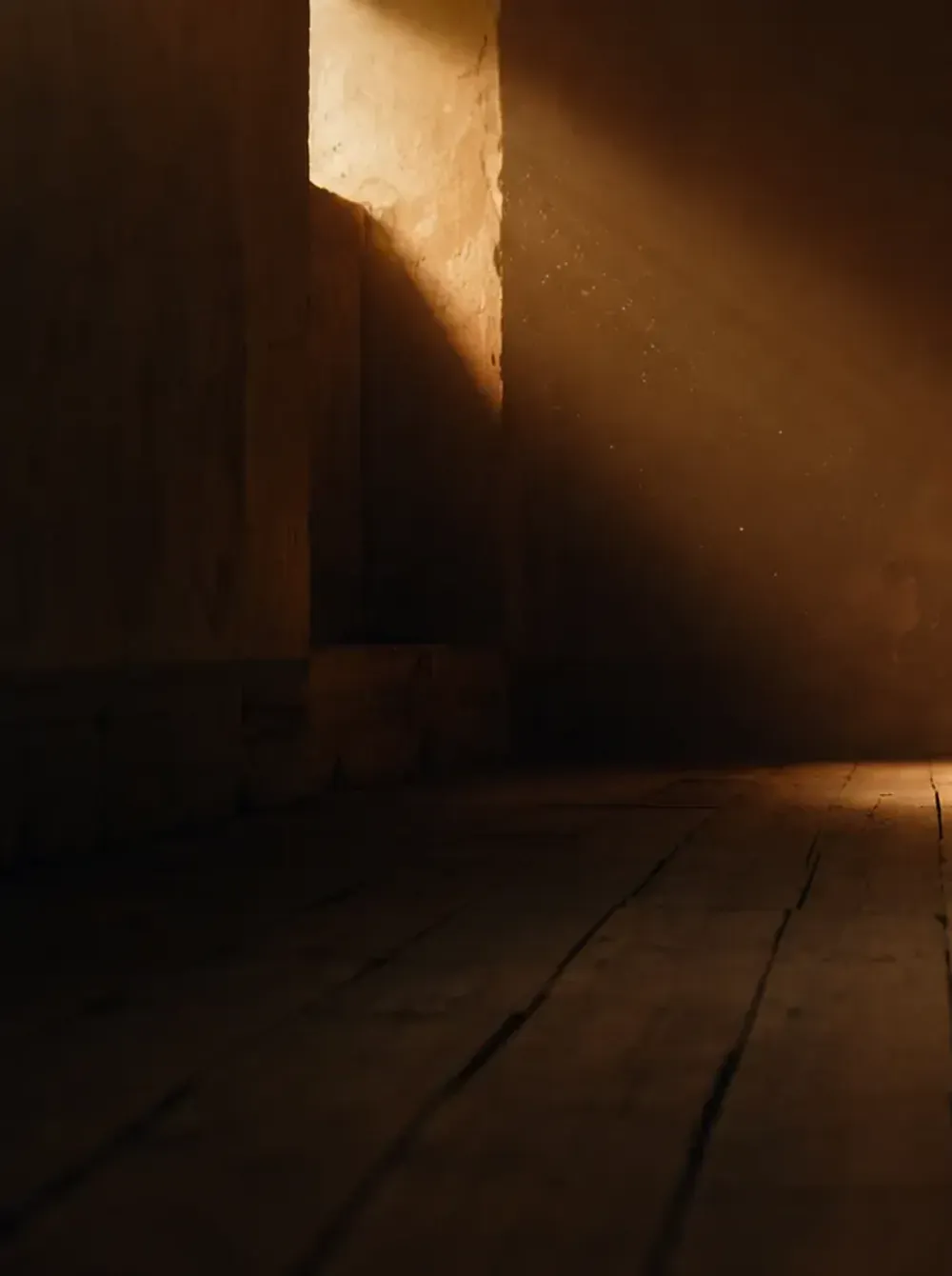 A dark detail crop of the Amselgrund hero: the doorway and stone wall to the left of the room.
