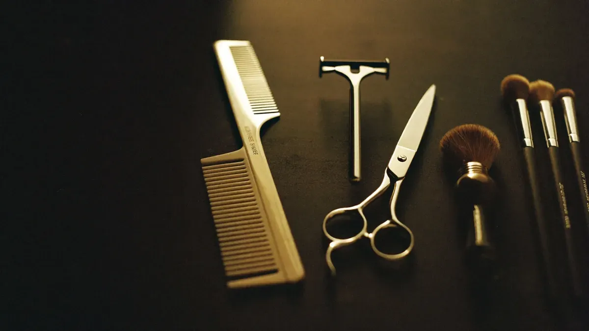 A close crop of salon and barber tools, lit in the same warm espresso-and-champagne tones as the rest of the page.